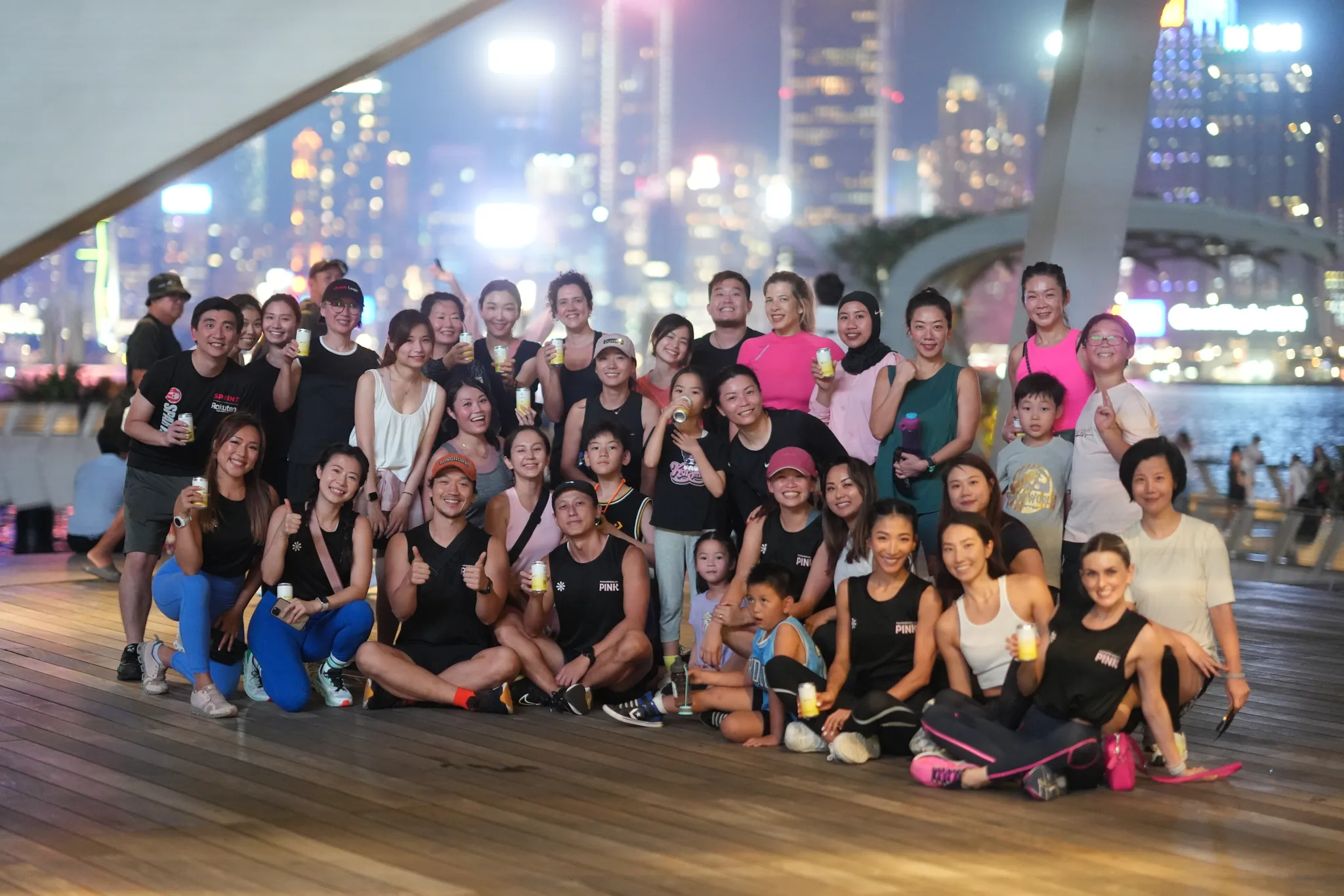 Group photo at an outdoor gathering beside Hong Kong's waterfront at night