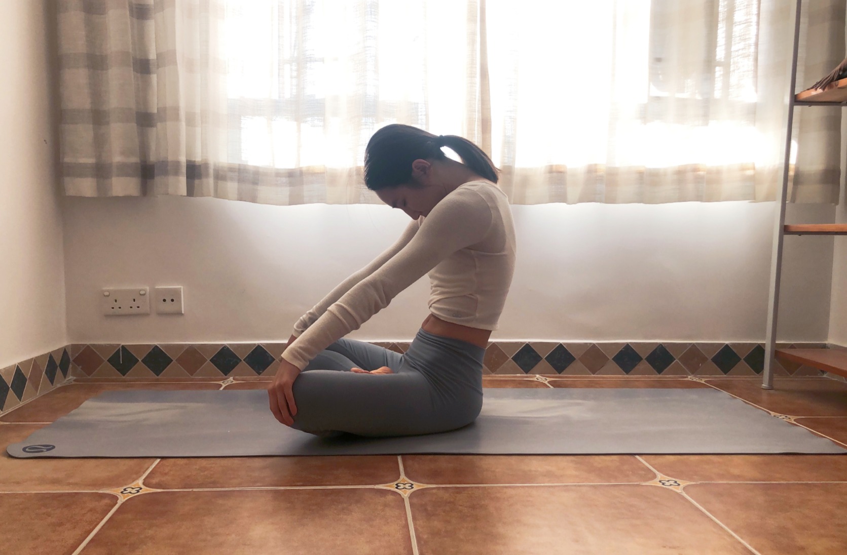 Seated Cat Pose with chin tucked and chest caved